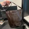 Bolso tipo cubo grande informal para mujer, nuevo modelo otoño 2026, alto valor estético, color liso, diseño de remaches, bolso de hombro simple para el día a día