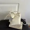 Nuevo bolso de cordón de lunares color crema para principios de otoño de 2026 con un ambiente relajado y elegante, bolso cruzado de un solo hombro a la moda, artístico y de nicho