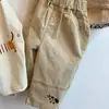Ropa infantil coreana 2026 otoño nuevo estilo salchicha conjunto de dos piezas camiseta top de manga larga para niños pantalones cargo casuales nuevo