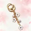 Colgante de llavero de aleación de doble flor más vendido transfronterizo, con lindos accesorios de flor de cerezo y perlas, adecuado para fundas de auriculares y bolsos