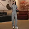 Conjunto feminino estiloso e casual para o outono de 2026: uma jaqueta curta e moderna com gola alta combinada com calças de perna larga, criando um conjunto esportivo de duas peças