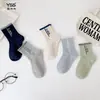 Calcetines infantiles Yishuangshuang, nuevos calcetines de tubo medio de marca de moda otoño e invierno, algodón peinado, rayas de bloques de color, calcetines sin costuras para niños