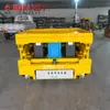 Camión industrial de plataforma baja alimentado por riel de bajo voltaje con postes conductores, Carro móvil alimentado por riel, Camión de plataforma eléctrica vertical hidráulico