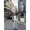 Foto real: Conjunto de duas peças de top de tricô sem alças cor de damasco, estilo puro e desejável de outono, com calça pantalona drapeada com punhos