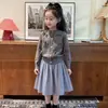 Ropa infantil estilo coreano 2026 colección otoño e invierno nueva: cárdigan de punto gris dulce con lazo para niña y falda de cuadros azules, moderno