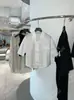 DestacadoYuran 26 Nueva Colección de Principios de Otoño: Camisa a la moda y estilizada de manga corta con cuello pequeño de solapa y borde sin rematar