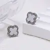 Pendientes de moda clásicos y versátiles, accesorios para orejas de cruz y trébol de cuatro hojas, elegantes y sencillos con un toque de alta gama, joyería con incrustaciones de diamantes para mujeres al por mayor