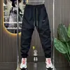 Nova coleção de primavera e outono: Calças corta-vento da moda, versáteis e confortáveis para homens, adequadas para esportes, atividades ao ar livre e uso casual; design de corte solto e perna afunilada