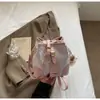 Nova Bolsa Saco de Design de Nicho 2026 para Mulheres, Bolsa Transversal Colorida Fashion com Cordão e Pingente de Pom-Pom Fofo, Sensação de Alto Padrão