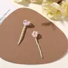 Design original: Acessórios de cabelo e enfeites de roupa florais em miniatura apresentando uma vibrante cena de prado verde com pequenas contas e galhos de flores retorcidos