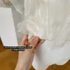 Camisa Plisada Fina Color Té Blanco con un Ambiente Suave, Bordes Irregulares con Volantes y Diseño Asimétrico Hombro Caído, Color Albaricoque Claro, con Etiquetas