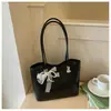 Bolso de hombro con lazo estilo coreano 2026 transfronterizo para mujer, bolso de axila de nicho, bolso tipo cubo moderno y simple para el trabajo diario para mujer