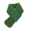 Bufanda de punto cálida y gruesa de estilo coreano para invierno para niños y niñas, protector de cuello infantil, a prueba de viento, color liso con etiqueta de cuero, venta al por mayor