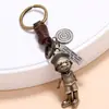 Chaveiro retrô personalizado de couro de vaca trançado com design criativo de mãos e pés de robô de desenho animado.