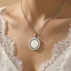 Colar com Pingente Redondo de Aço Inoxidável com Mãos em Oração, Cravejado com Zircônia, Disponível nas Cores Dourado, Preto e Aço, Acessório da Moda para Homens e Mulheres