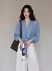 Camisa azul listrada estilo coreano com decote V para mulheres, outono inicial de 2026, com design cruzado, cintura marcada e detalhe de amarração, criando um efeito emagrecedor, adequada para o trabalho
