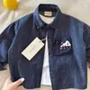 Camisa jeans macia de outono para meninos, novo estilo primavera/outono 2026, camisa de manga comprida para bebês e crianças maiores, peça externa da moda