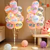 Decoración de escena para el primer cumpleaños con globos de macarrón y pilares, creando un ambiente de fiesta para fotos de bebé