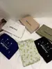 Bolsa de cosméticos pequeña y fresca con bordado de alta gama para mujer, bolsa de almacenamiento portátil de lona interior de gran capacidad con acabado, bolsa de lavado de maquillaje