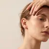 Populares en Europa y América, estos pendientes de botón de circonita cúbica de nicho para mujer presentan un diseño minimalista, estilo de aro simple y un acabado dorado, ofreciendo un look sofisticado para el uso diario.