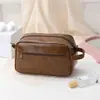 Bolsa de maquiagem portátil masculina de alta qualidade com armazenamento compartimentado, 2026 bolsa de higiene pessoal portátil de grande capacidade em PU para viagens de negócios