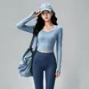 Conjunto de fitness Pilates profissional para mulheres, apresentando um top de gola redonda, amigável à pele e de secagem rápida, com bojos embutidos, e calças de yoga de manga longa, cintura alta e justas ao corpo.