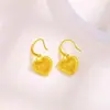 Tienda de oro con pendientes huecos de color dorado en forma de corazón y trébol de cuatro hojas, pendientes de color alto dorado claro para novia