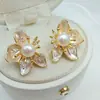 Aretes de botón de flor de perla natural y circonita dorados en oro real, aretes de moda y elegantes, estilo de lujo ligero con un diseño único, aretes de nicho