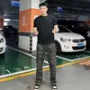 Calças de camuflagem estilo retrô americano, levemente boca de sino, para homens, coleção de outono, com corte inclinado, design de perna reta e um estilo workwear inspirado em lenhador, lembrando calças jeans curvas.