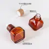 Botella cuadrada de vidrio marrón de alta gama con gotero para suero para el cabello de 30 ml, de madera de bambú personalizada, engrosada, para aceites esenciales para el cuidado del cabello, OEM