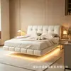 Cama grande de cuero color crema con tapicería suave y abullonada, cama flotante minimalista, dormitorio principal atmosférico con diseño suspendido y tira de luz integrada, dormitorio doble