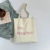 Bolsa de Lona com Estampa de Letras Nova Primavera Grande Capacidade Bolsa de Ombro Feminina Simples Fresca Versátil