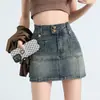 Minifalda de mezclilla retro americana para mujer, nuevo estilo verano 2026, anti-exposición, de cintura alta, ajustada, falda midi de línea A