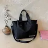Bolsa de Mão Patchwork Color Block Bolsa de Tecido de Nylon 2026 Novo Estilo Letras Estampadas Sensação de Luxo Bolsa de Ombro Transversal Repelente à Água