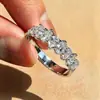 La banda de medio anillo de diamante en forma de pera dulce de Cao Shi con un diseño de arco de lágrima es un anillo brillante y versátil para el uso diario