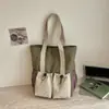 Bolsa tote casual minimalista de nicho estilo coreano em nylon com design único, grande capacidade, alto apelo estético e design de fecho de cordão, adequada para carregar na mão ou no ombro
