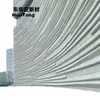 Muro cortina prefabricado de GRC de forma irregular con líneas fluidas, hecho de hormigón visto, para la fachada de una calle comercial cultural y creativa de moda.