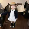 Coleção nova de outono 2026 para meninas, estilo coreano: vestido de renda com laço branco, combinado com um cardigã de tricô moderno