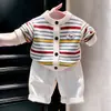 Ropa infantil coreana 2026 otoño e invierno nuevo suéter a rayas de colores cárdigan de punto pantalones casuales blancos para niños conjunto de dos piezas