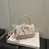 Bolsa feminina de nicho estilo coreano com laço, novo modelo 2026, bolsa de ombro única e transversal, bolsa de mão de alta qualidade com poás, bolsa quadrada pequena