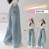 Roupa Infantil Meninas Jeans Primavera e Outono 2026 Novo Estilo Outono Meninas Bolsos Laço Strass Jeans de Perna Curva