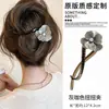 Um grampo de cabelo estiloso e versátil para mulheres, apresentando um design de bico de pato que não pressiona a parte de trás da cabeça, perfeito para criar penteados elegantes no outono e inverno.