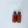 Frasco de amostra translúcido marrom de 50ml com tampa flip-top, ombro arredondado e fundo arredondado, para shampoo, condicionador, loção, tamanho de teste, frasco reutilizável