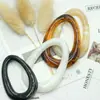 Venta al por mayor del fabricante en stock de hebillas de resina ovaladas con forma de gota de agua para cinturón, hebillas para chaquetas de cuero, hebillas de dos posiciones, hebillas de conexión para trajes de baño, hebillas decorativas