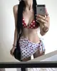 Traje de baño para mujer sensación de alta gama 2026 nuevo estilo bloques de color lunares rojos bikini de dos piezas para vacaciones en aguas termales tomar fotos absolutamente hermoso