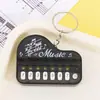 Mini Piano de Mano Llavero Teclado Electrónico Infantil Llavero de Dibujos Animados Colgante Juguete Creativo Toca y Se Ilumina