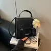2026 Nuevo Estilo Femenino Bolso Cuadrado Pequeño con Solapa Tejida Bolso de Mano con Colgante de Oso Pequeño y Lazo Se Puede Llevar Cruzado Mini