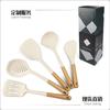 Nuevo juego de utensilios de cocina de silicona con mango de madera transfronterizo dedicado de 12 piezas, sartén antiadherente resistente a altas temperaturas, cuchara para sopa, colador y pala.