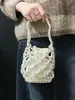 Elegante y versátil bolso de mujer 2025 nuevo modelo casual hecho a mano bolso de mano tejido hueco con cuentas plateadas