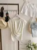 Camiseta de punto de seda helada de manga corta de color albaricoque con diseño cruzado irregular para mujer, para usar en verano con un elegante diseño que ciñe la cintura.